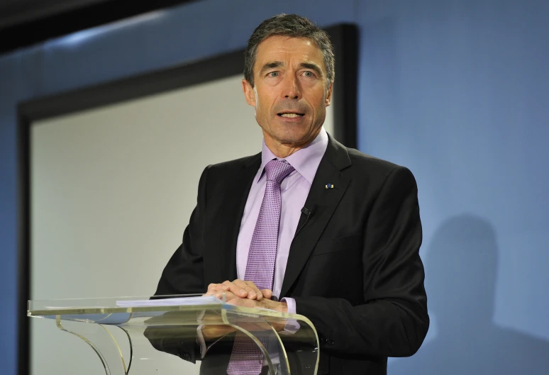 a man stands behind a podium giving a speech