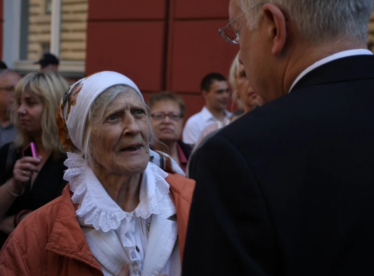 an old woman has on a headscarf next to an older man