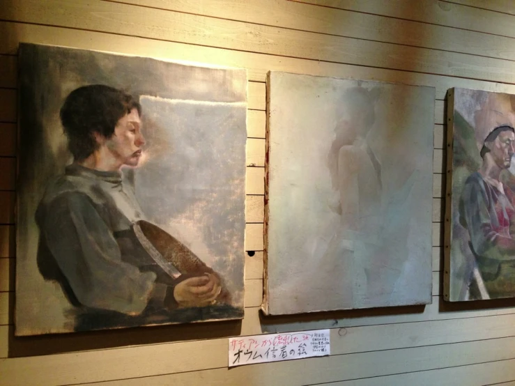 a man holding a small guitar between two paintings