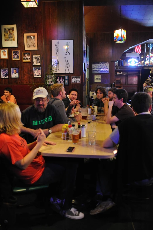 a group of people sitting at a bar eating