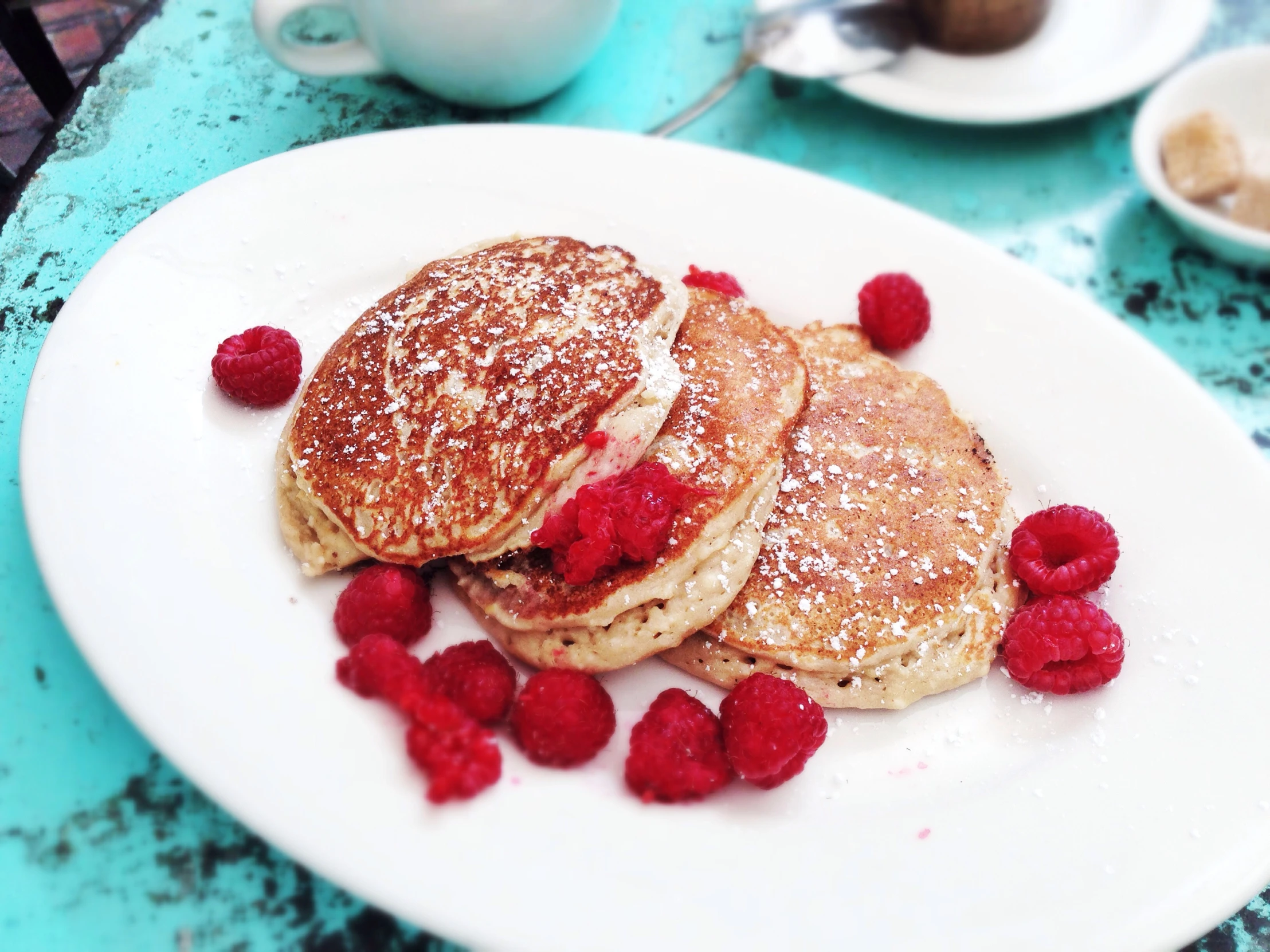 there are some pancakes with raspberries on the white plate