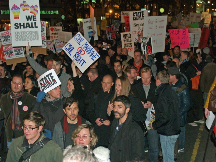 a large group of protesters holding placards at night