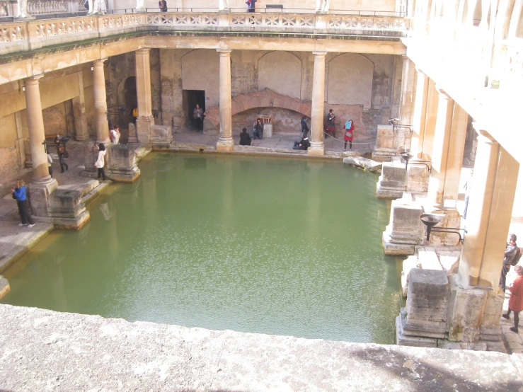 people are standing around a large pool with water