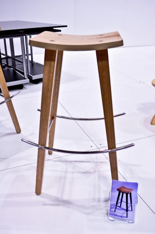 a wooden stool next to a table and chair