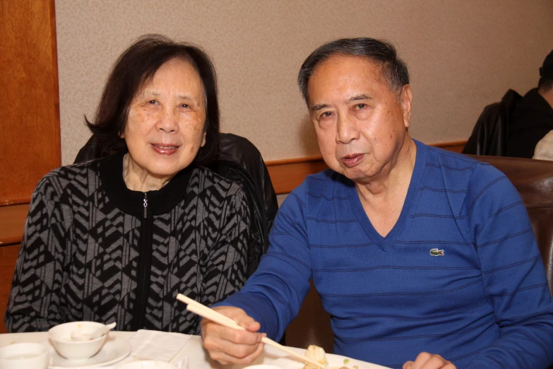 two asian people seated at a dinner table