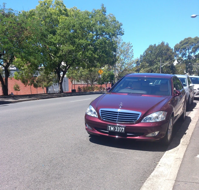 red car parked on the side of a city road