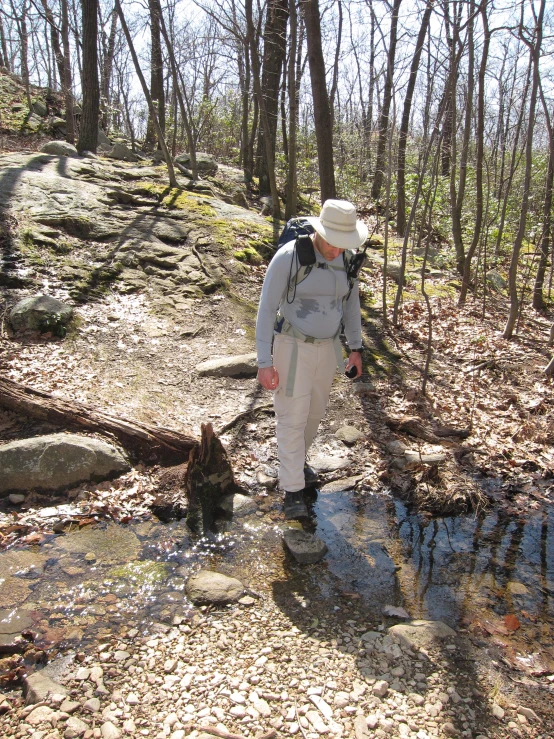 a person crossing some small stream while on a hike
