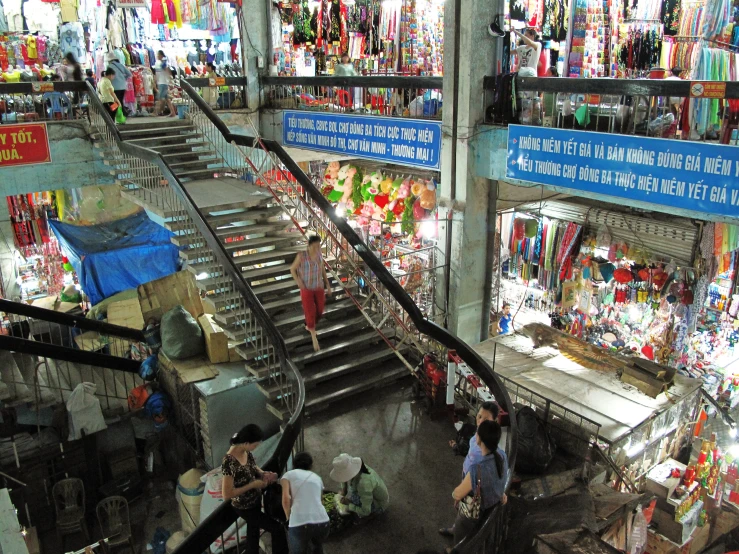 a group of people walking down a street next to an outdoor mall