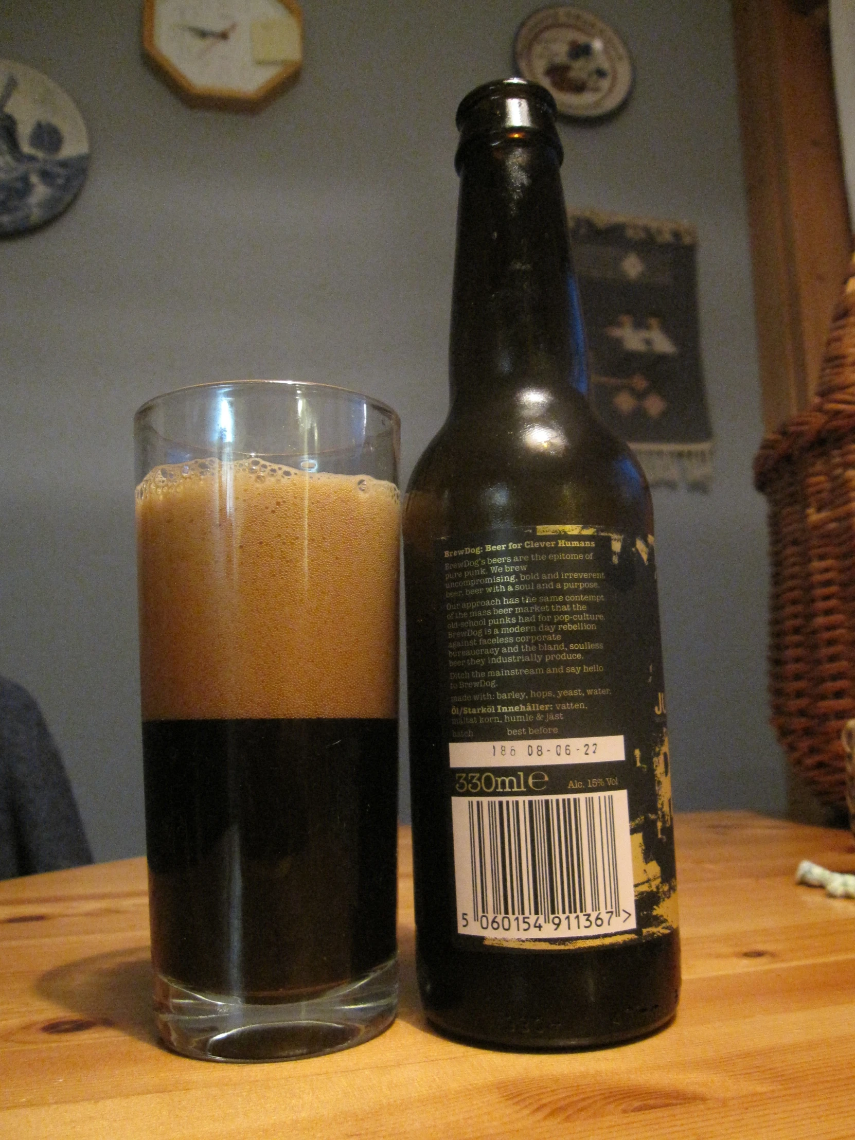 a glass with a brown liquid on a wooden table