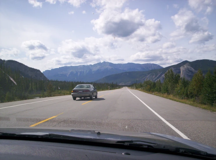 there is a small suv that is driving down the road