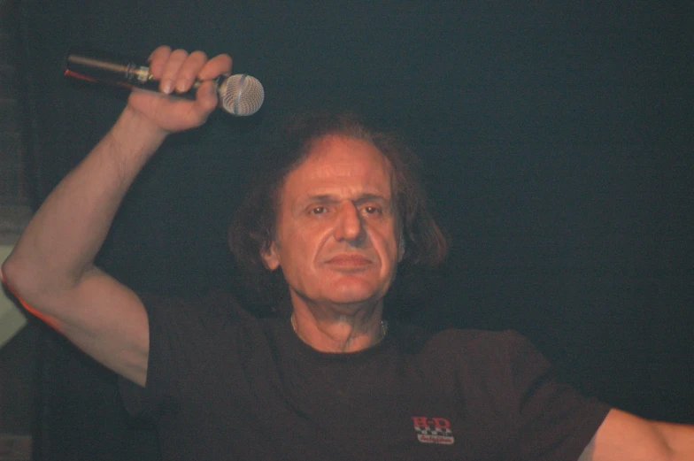 a man is holding a microphone in the air