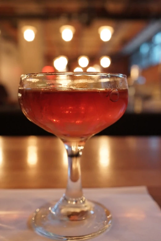 a cocktail is sitting in a coupe glass on a table