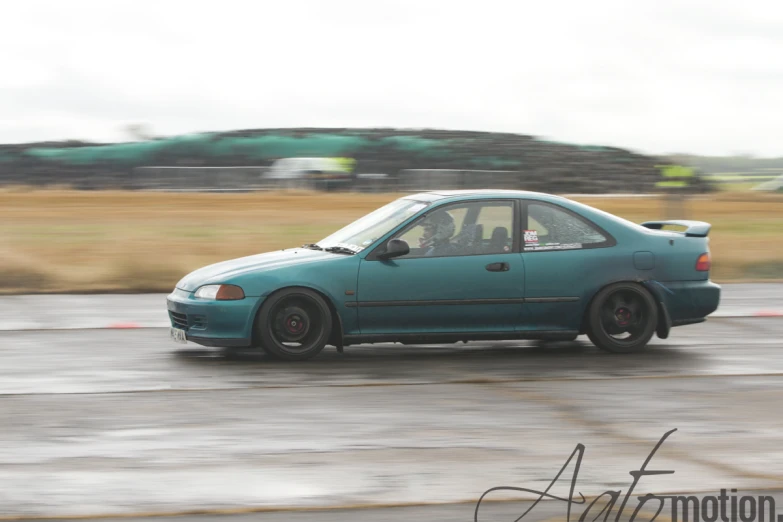 a small car drives along an asphalt road