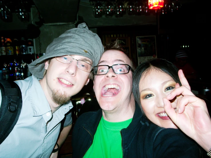 three people posing for a po in front of a bar