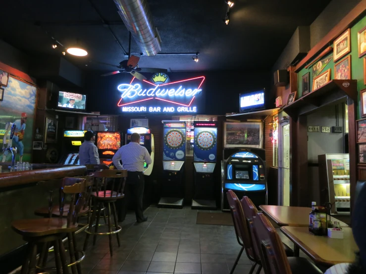a man standing at a bar by a slot machine