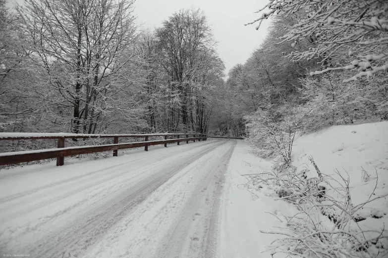 the snow is covered and there are cars driving in front