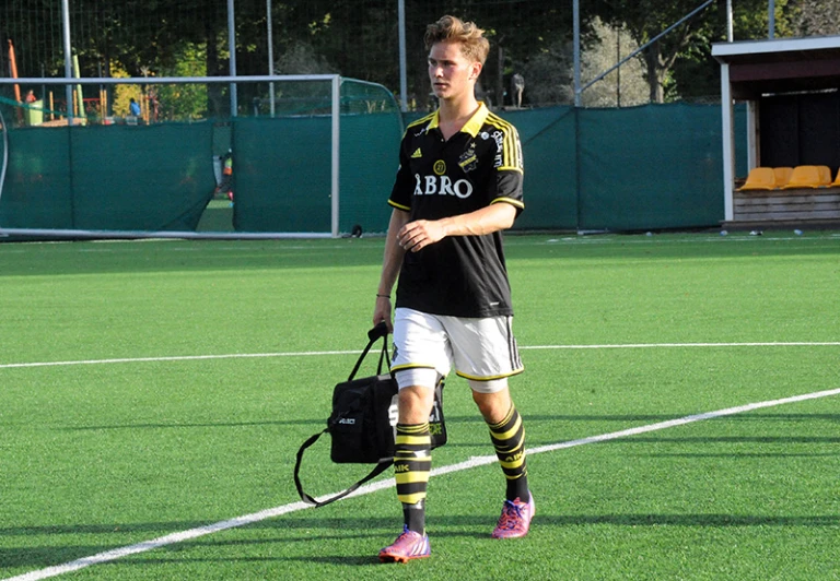 man on a soccer field with a backpack and football gloves