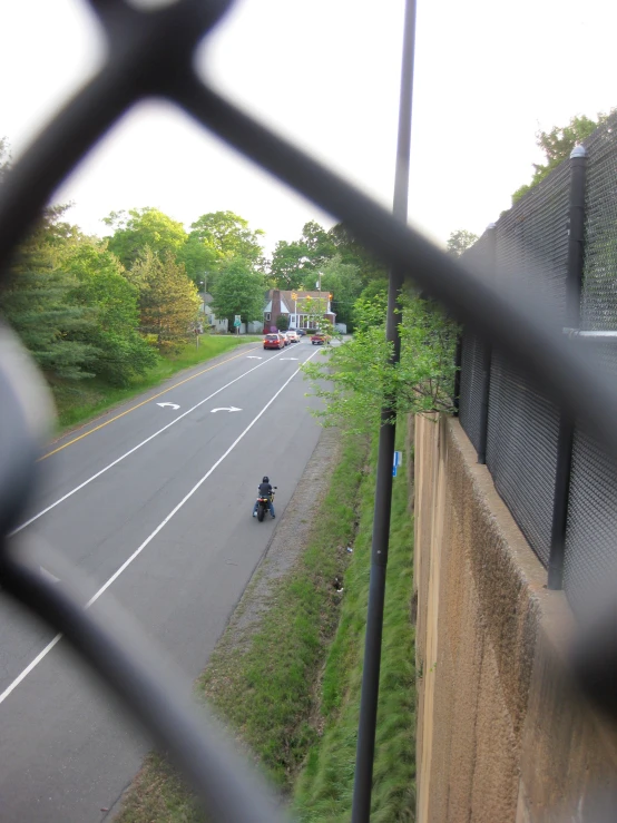 there is an view of the back roads from inside a fence