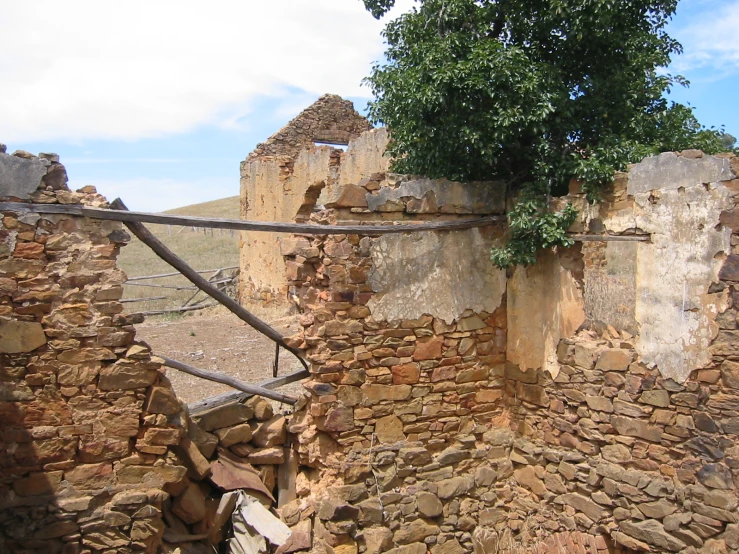 an old wall of rocks and a wooden hand rail