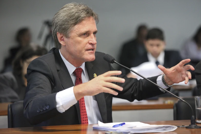 a man in a suit speaking in front of a crowd