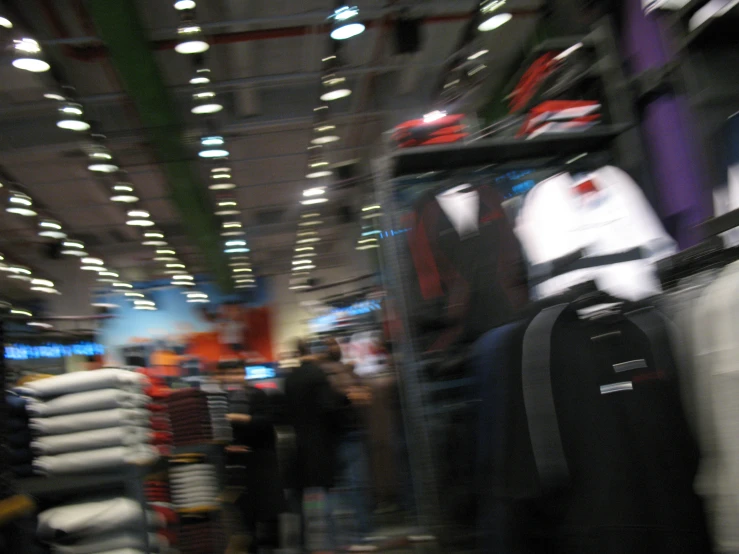 a crowded shopping area with some luggage in the background