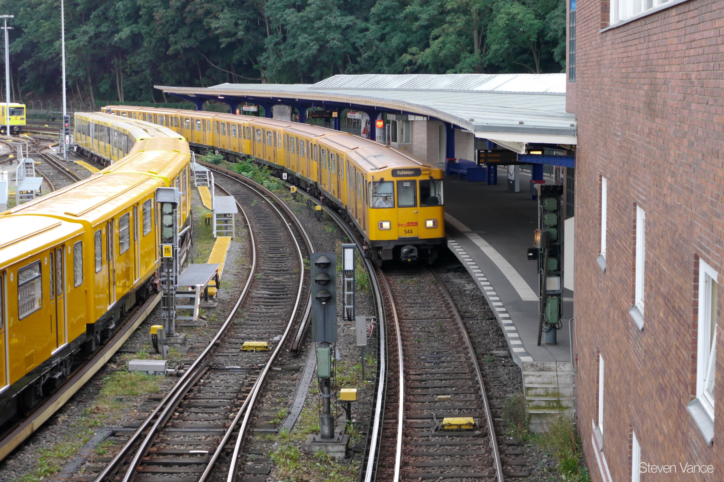 yellow trains lined up next to each other at a station