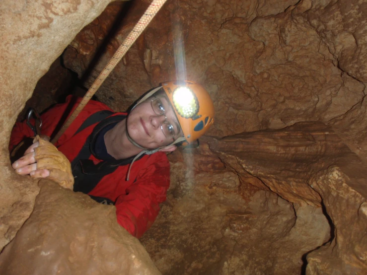 a man is wearing a helmet and looking up from inside a cave