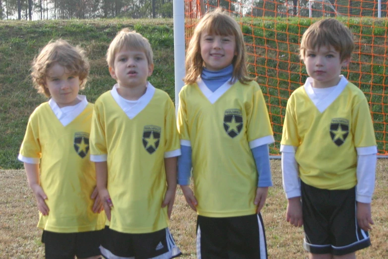 a group of s standing next to each other in soccer uniforms