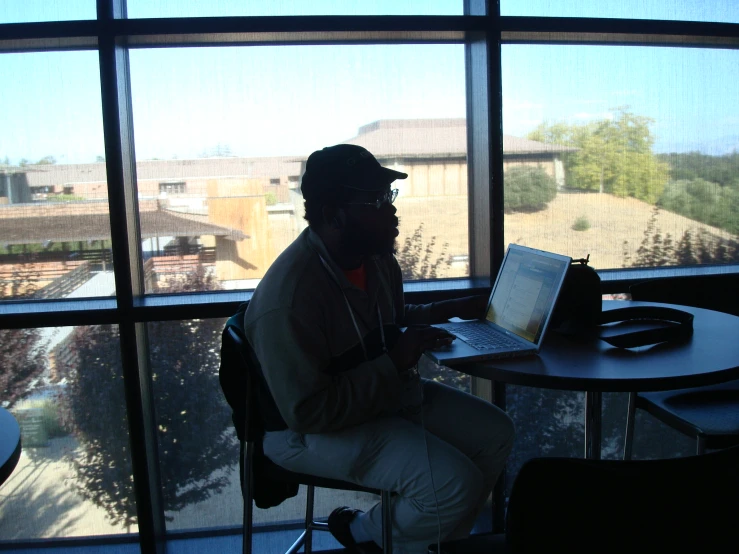 a person sitting at a table on a laptop