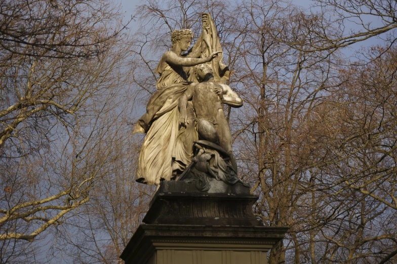a statue of a woman riding a horse that has birds on its back