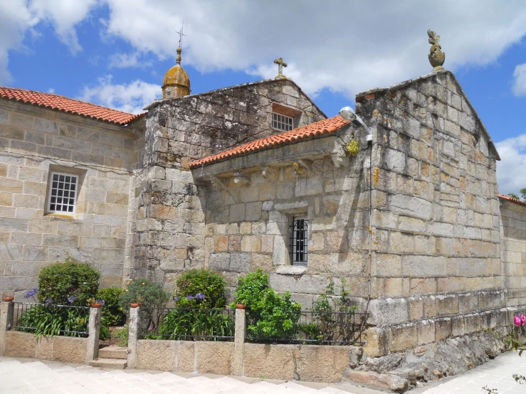 an old stone building sitting on top of a dirt field