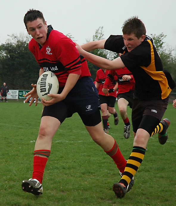 boys playing rugby in red and black uniforms