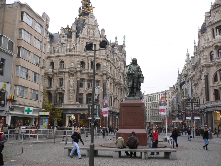 a large brown building next to a street filled with people