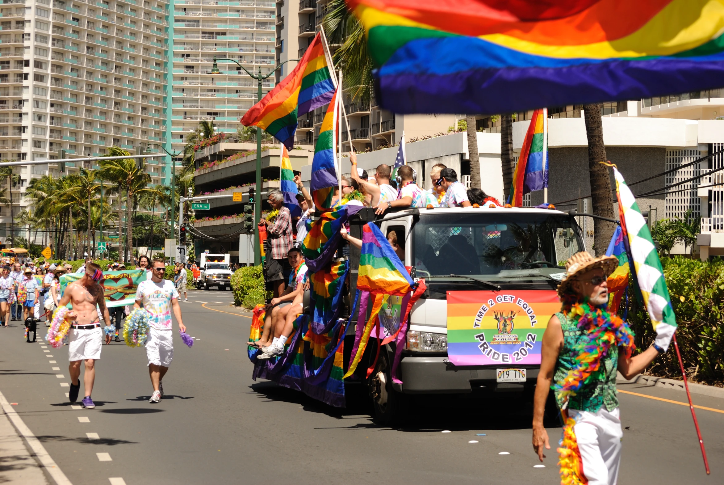 a parade with a bus and people walking on the street