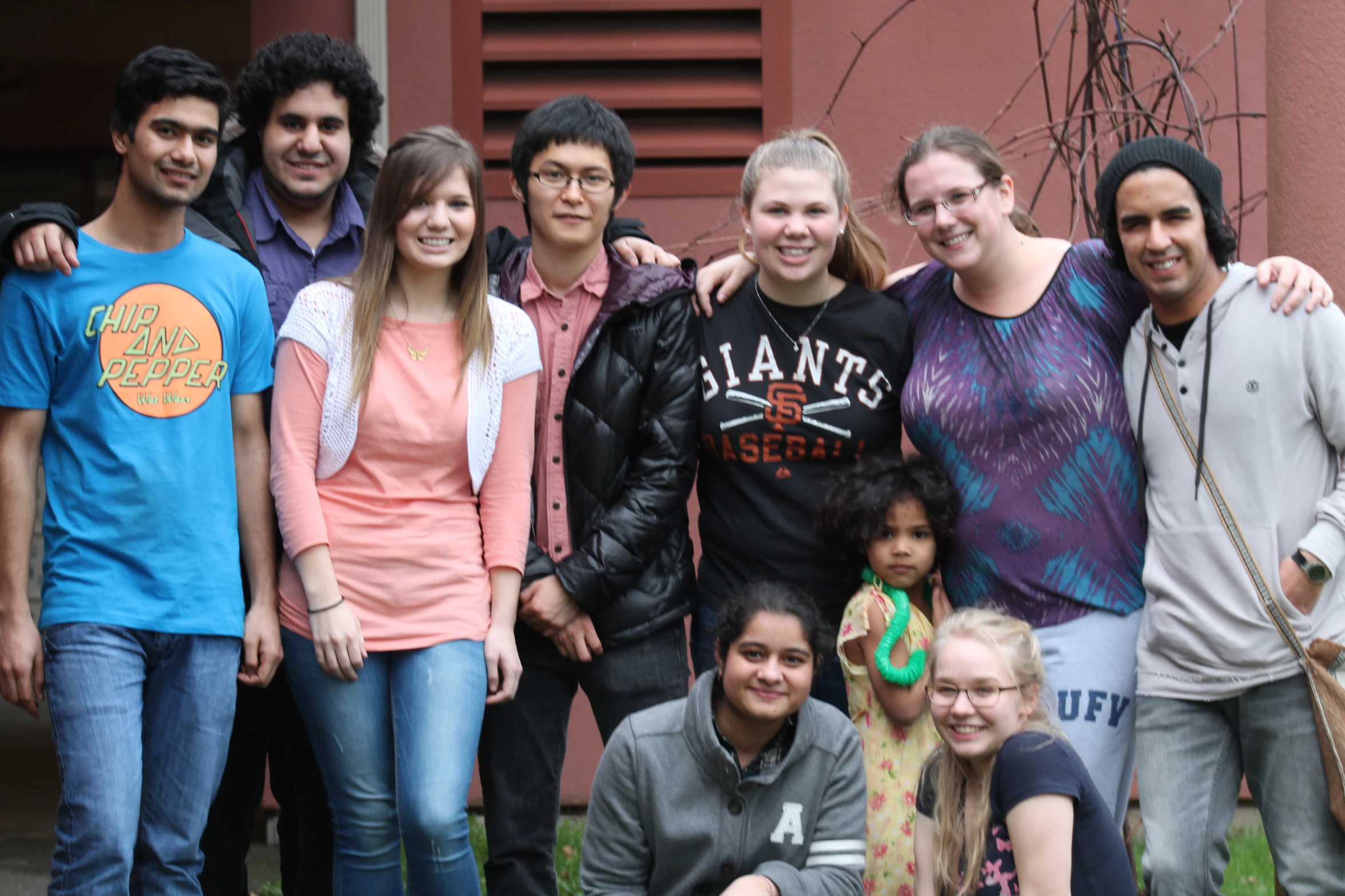 a group of people standing and sitting in front of a building