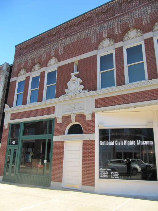 the front entrance of a building next to a car