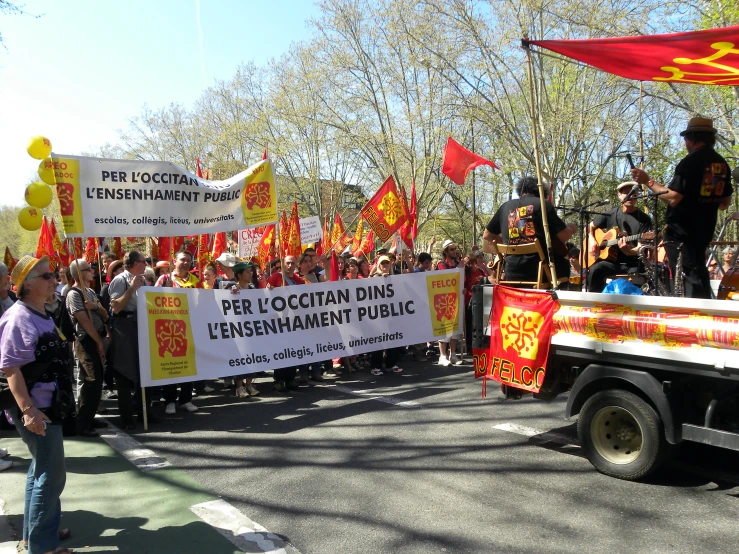 people are on a parade float, one is carrying a sign