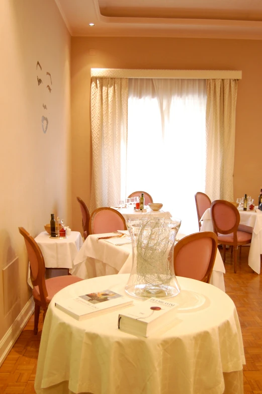 a restaurant table with three chairs and two vases on the dining room table