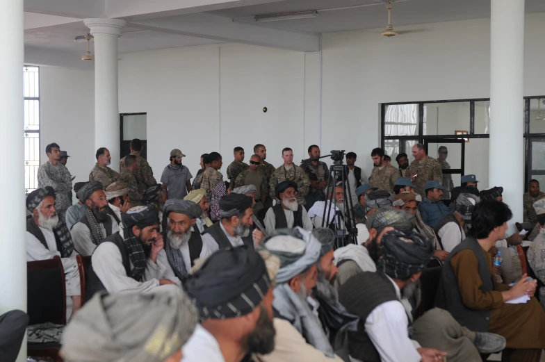 a group of men in military clothing are sitting next to each other