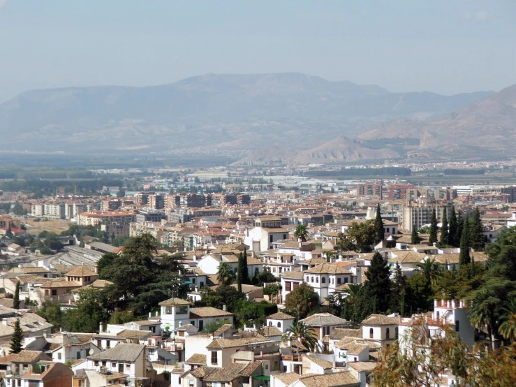 a view of an area with many buildings, hills and water