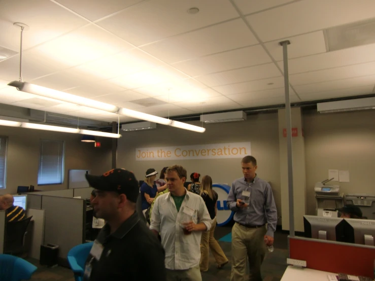 a group of people walking in the hallway of an office