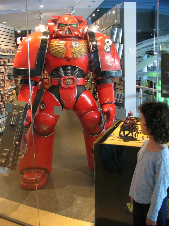 people looking at large red and black robot toy