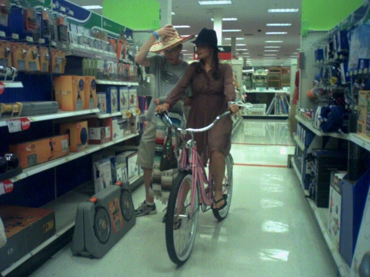 man with hat riding a bike in a store