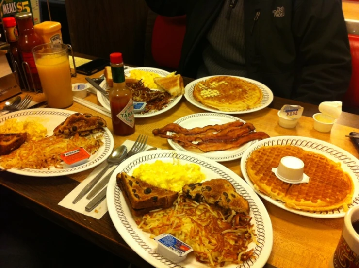 plates and pancake's are stacked together on a table