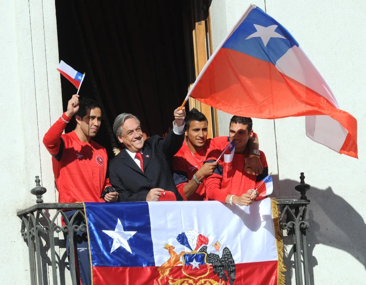 a couple of men standing in front of a flag waving