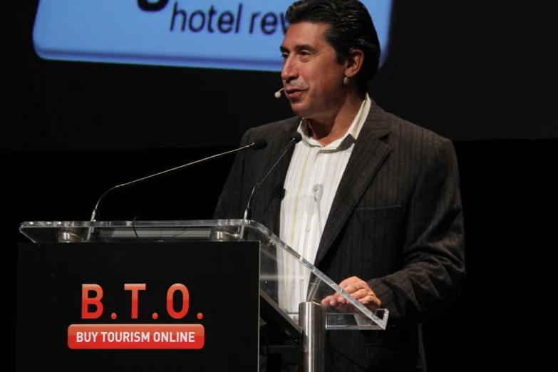 a man in a suit and tie giving a speech at an event