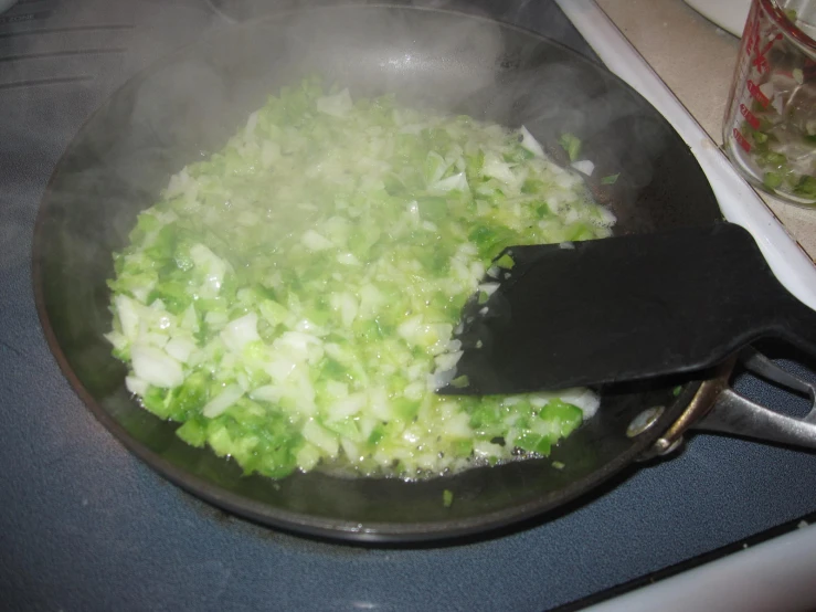 a pan filled with some green food on top of the stove