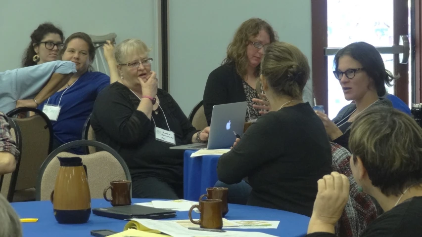 a group of people sitting in front of laptops