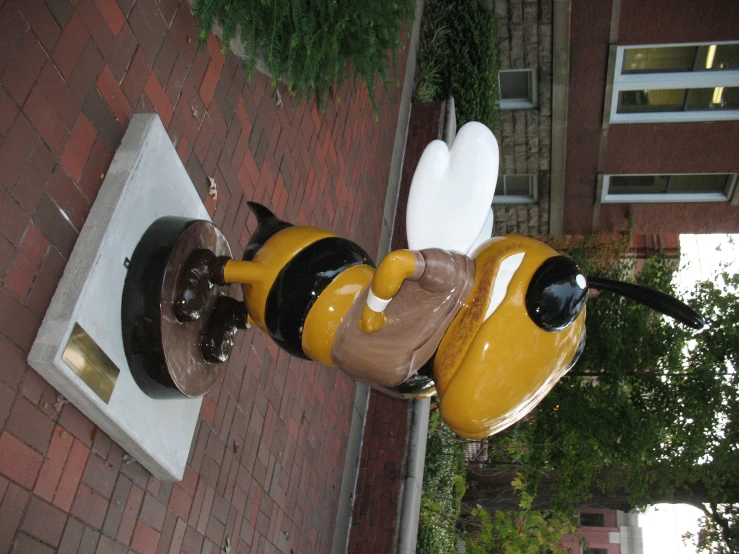 a yellow and black bee figurine sitting on top of a white block