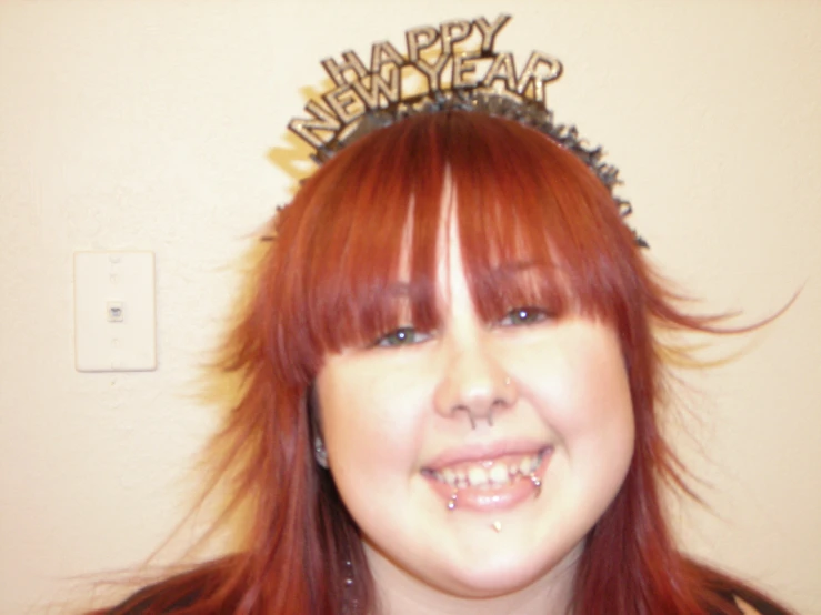a young red headed woman wearing a happy new year's crown